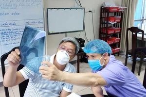 Thứ trưởng Bộ Y tế Nguyễn Trường Sơn (trái) trực tiếp theo dõi tình hình sức khỏe bệnh nhân Covid-19 tại Bệnh viện Phổi Đà Nẵng. Ảnh: NGUYỄN CƯỜNG