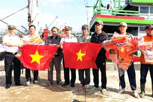 Vùng 4 Hải quân tặng cờ tổ quốc cho ngư dân Bình Định. Ảnh: NGỌC OAI