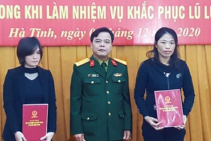 Đại tá Lê Hồng Nhân - Chỉ huy trưởng Bộ CHQS tỉnh trao các quyết định tuyển dụng cho vợ của 2 liệt sĩ