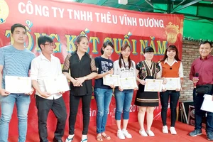  Anh Liêu Ngọc Sơn (bìa phải), Bí thư Chi bộ, Chủ tịch Công đoàn Công ty TNHH thêu Vĩnh Dương (quận Tân Phú, TPHCM) trao giấy khen cho đoàn viên có thành tích tốt trong sản xuất