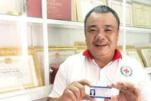Chú Nguyễn Văn Tác phấn khởi cầm thẻ đăng ký hiến tạng trên tay