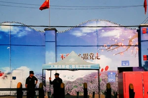 Nhân viên bảo vệ đứng ở cổng của trung tâm giáo dục kỹ năng nghề ở Tân Cương. Ảnh: REUTERS