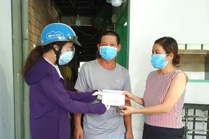 Đại diện chương trình “Một gia đình trợ giúp một gia đình” trao hỗ trợ gia đình anh Lê Văn Còn (phường 28, quận Bình Thạnh)