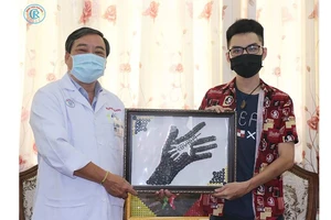Anh Nguyễn Phước Quý Thành trao tặng tranh cho đại diện Bệnh viện Chợ Rẫy TPHCM.