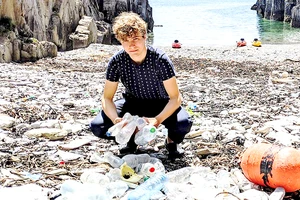 Fionn Ferreira bên bờ biển đầy rác thải nhựa