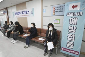 Người dân tuân thủ giãn cách chờ tiêm vaccine COVID-19 tại Seoul. Ảnh: AP
