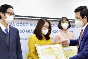 Vụ trưởng Vụ Khoa học, Công nghệ và Môi trường (Bộ GDĐT) Tạ Ngọc Đôn trao giải Nhất cho các giảng viên trẻ đoạt giải. Nguồn: Bộ Giáo dục