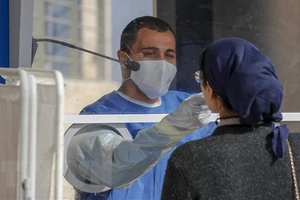 Nhân viên y tế Israel lấy mẫu xét nghiệm COVID-19 cho người dân tại Jerusalem