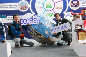 Phạm Thanh Trí (bên trái) cùng thành viên EFV và mô hình “cá voi tre khổng lồ” phân loại rác