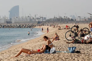 Du khách trên bãi biển ở Barcelona (Tây Ban Nha). Ảnh: Reuters