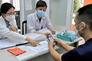 Bác sĩ thực tập Nguyễn Thị Quỳnh Trang khám, tư vấn cho người dân tại Trạm y tế phường Hiệp Thành, quận 12. Ảnh: QUANG HUY