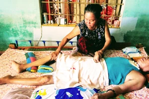 Bà Trần Thị Tiếp chăm sóc người chồng bị đột quỵ, nằm liệt giường gần 10 năm qua