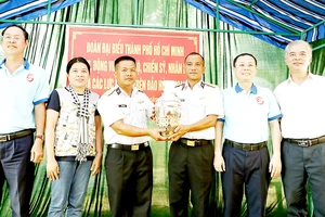 Phó Bí thư Thành ủy TPHCM Nguyễn Văn Hiếu cùng các đại biểu tặng quà cho Trạm radar 595. Ảnh: NGÔ BÌNH