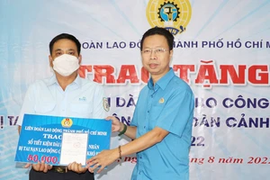 Đại diện Liên đoàn Lao động TPHCM tặng sổ tiết kiệm trị giá 50 triệu đồng cho anh Phạm Hoàng Khôi (TP Thủ Đức)