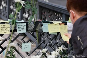 Một người đàn ông đăng thông điệp chia buồn vào ngày 1-11-2022, gần ga Itaewon cho những người thiệt mạng trong vụ giẫm đạp trong lễ hội Halloween tại Itaewon. Ảnh: Yonhap