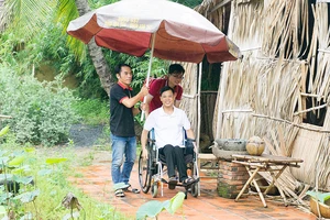 Thành viên CLB chụp ảnh cưới miễn phí hỗ trợ chú rể khuyết tật di chuyển đến nơi chụp ảnh. Ảnh: HỒNG HÀI