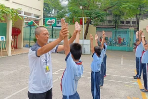 Thầy Hồ Xuân Hùng, giáo viên Trường Tiểu học Phú Thọ (quận 11), tận tình chỉ dẫn học sinh trong từng động tác