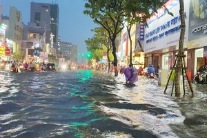 Người dân khơi thông miệng cống trong đêm mưa lũ 14-10 tại đường Nguyễn Văn Linh (quận Hải Châu, TP Đà Nẵng). Ảnh: XUÂN QUỲNH