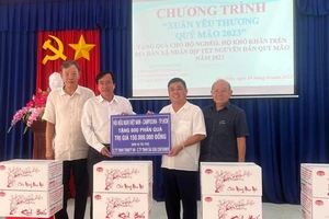 Phó Chủ tịch Hội Hữu nghị Việt Nam - Campuchia TPHCM Trang Hữu Nghĩa (thứ hai từ phải qua) cùng các nhà tài trợ trao bảng tượng trưng tặng 600 phần quà tết