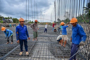 Các công nhân đang thi công đường cao tốc Mỹ Thuận - Cần Thơ. Ảnh: TUẤN QUANG