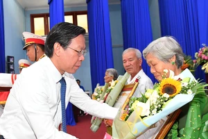 Chủ tịch UBND TPHCM Phan Văn Mãi trao danh hiệu Bà mẹ VNAH cho thân nhân mẹ. Ảnh: VIỆT DŨNG 