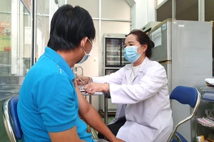 Nhân viên Trung tâm Y tế Quận 8 (TPHCM) tiêm vaccine Covid-19 cho người dân. Ảnh: THÀNH SƠN