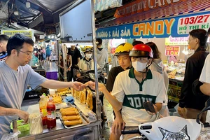 Du khách trải nghiệm ẩm thực tại khu chợ đêm Hồ Thị Kỷ, quận 10, TPHCM. Ảnh: HOÀNG HÙNG