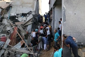 Người dân tìm kiếm người bị mắc kẹt trong những đống đổ nát sau vụ không kích của Israel tại Khan Younis, Dải Gaza, ngày 11-10-2023