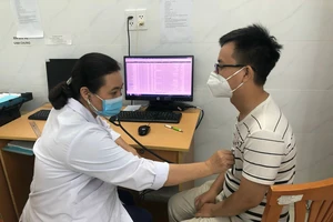 Bác sĩ CKII Trần Thị Vân Anh, Trưởng khoa Nội nhiễm, Bệnh viện Thống Nhất TPHCM thăm khám cho bệnh nhân Ảnh: KIM HUYỀN