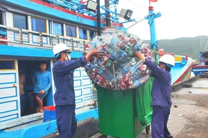 Các nhân viên môi trường cảng cá Quy Nhơn tiếp nhận rác thải nhựa từ 1 tàu đánh cá ngừ để đưa về khu phân loại, tái chế