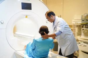 Kỹ thuật viên khoa Chẩn đoán hình ảnh, Bệnh viện Chợ Rẫy hỗ trợ bệnh nhân chụp MRI kiểm tra sức khỏe. Ảnh: MINH NAM