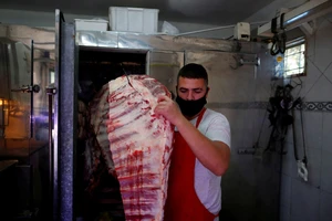 Anh Pablo Alberto Monzon chuẩn bị thịt bò tại cửa hàng ở ngoại ô thủ đô Buenos Aires, Argentina. Ảnh: REUTERS
