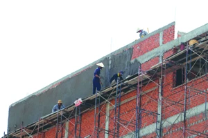 Công nhân xây dựng làm việc trên tầng cao công trình xây dựng nhà ở trên đường Cộng Hòa (quận Tân Bình, TPHCM) thiếu trang bị bảo hộ lao động. Ảnh: NGÔ BÌNH