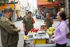 Lực lượng bảo vệ an ninh trật tự ở cơ sở phường Nguyễn Thái Bình, quận 1 trao đổi với người dân. Ảnh: THU HƯỜNG