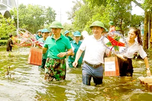 Các nghệ sĩ và các tổ chức, đoàn thể địa phương đến tận nhà những em nhỏ vùng bị ngập lụt ở Hà Nội để trao quà Trung thu. Ảnh: THU HÀ