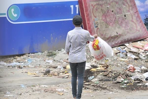 Vô tư vứt rác vào một bãi rác tự phát Ảnh: THÀNH TRÍ