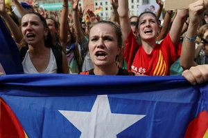 Một phụ nữ cầm cờ ly khai của Catalonia trên đường phố Barcelona hôm 2/10. Ảnh: Reuters.