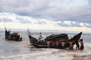 Ngư dân đẩy thuyền ra khơi sau cơn bão vừa tan