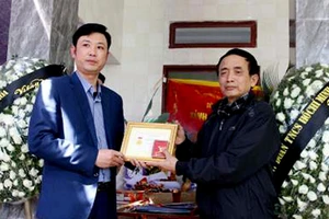Bí thư Tỉnh đoàn Thanh Hóa Lê Văn Trung truy tặng Huy hiệu “Tuổi trẻ dũng cảm” cho thân nhân em Hoàng Đức Hải. Ảnh: TTXVN