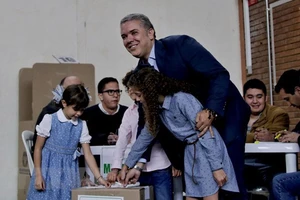 Ứng viên Tổng thống Colombia Ivan Duque (phải) bỏ phiếu tại điểm bầu cử ở Bogota ngày 17/6. (Nguồn: THX/TTXVN)