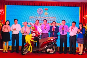 Ban lãnh đạo Công ty Yến Sào Khánh Hoà trao thưởng cho khách hàng trúng thưởng xe máy Honda SH Mode. Ảnh: HỒNG MINH