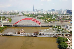 Cầu xe lửa Bình Lợi mới đang được xây giữa cầu xe lửa cũ và cầu đường bộ mới Ảnh: HOÀNG HÙNG
