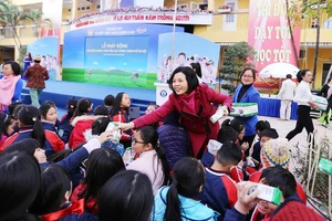 Bà Bùi Thị Hương, Giám đốc Điều hành Vinamilk trao sữa cho các em học sinh tại Lễ phát động thực hiện chương trình Sữa học đường tại thủ đô Hà Nội, đầu tháng 1-2019. Ảnh: VNM