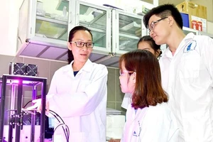 TS Nguyễn Tuyết Phương (bìa trái) hướng dẫn sinh viên nghiên cứu về pin mặt trời