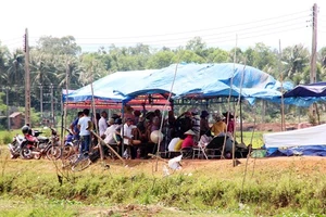 Người dân thôn Châu Trúc dựng rạp canh giữ 3 ô tô (trong đó 2 xe công vụ) để mong được đối thoại với lãnh đạo tỉnh Bình Định về dự án điện mặt trời, vào tháng 7-2018. 