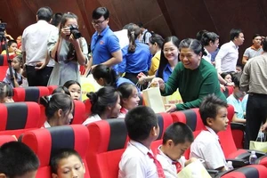 Phó Chủ tịch Quốc hội Tòng Thị Phóng xuống từng hàng ghế để tặng quà cho các em thiếu nhi. Ảnh: congthuong.vn