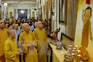 Các Chư tôn giáo phẩm cùng đông đảo phật tử tham quan triển lãm văn hóa nghệ thuật Phật giáo với hơn 500 tác phẩm từ tranh ảnh, tượng và sản phẩm điêu khắc tại tuần lễ văn hóa. Ảnh: TTXVN