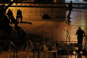 Các công nhân Israel di rời những thiết bị dò kim loại bên ngoài đền thờ Al-Aqsa ở Jerusalem ngày 25-7. Ảnh: TTXVN