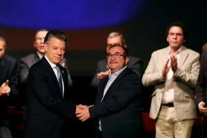 Tổng thống Colombia bắt tay lãnh đạo nhóm FARC trong lễ ký kết thoả thuận hoà bình năm 2016. Ảnh REUTERS
