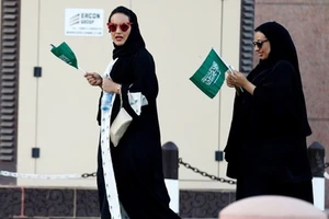 Phụ nữ cầm quốc kỳ Saudi Arabia mừng Quốc khánh ở Riyadh. Ảnh: REUTERS